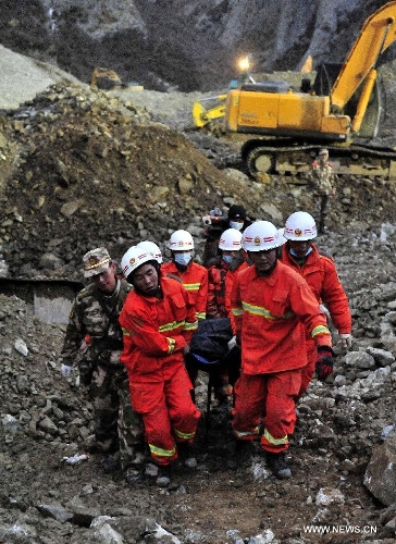 Firefighters carry a body at the site where a large-scale landslide hit a mining area in Maizhokunggar County of Lhasa, southwest China's Tibet Autonomous Region, March 30, 2013. Rescuers have found two bodies and are still searching for survivors more than 37 hours after a massive landslide buried 83 miners at the polymetal mine in Tibet. (Xinhua/Chogo) 