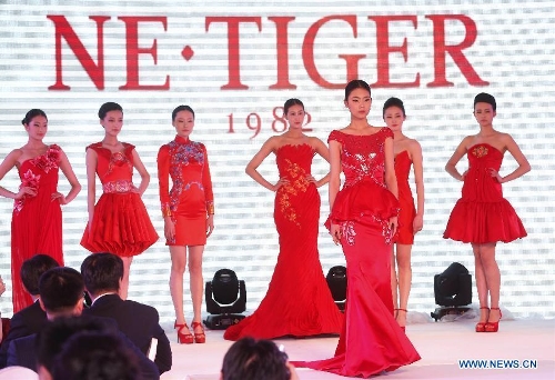Models present creations during a fashion show of NE·TIGER's high-end formal gowns in Qingdao, east China's Shandong Province, April 19, 2013. (Xinhua/Li Ziheng) 