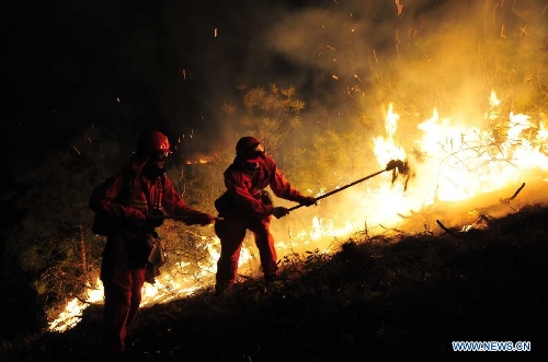 Forest policemen try to put out a forest fire in Anning, southwest China's Yunnan Province, April 9, 2013. The fire broke out around 1 p.m. (0500 GMT) in Anning City. Forest policemen and firefighters have been mobilized to quench the fire. (Xinhua/Zhong Yaojun) 