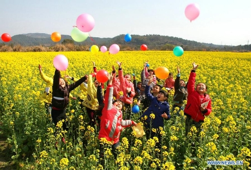 Pupils enjoy themselves in a cole flower field at Shixia Village in Renshou Township of Jing'an County, east China's Jiangxi Province, March 4, 2013. (Xinhua/Xu Zhongting) 