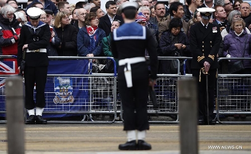 Soilders solute along the route of the gun carriage carrying the coffin containing the body of former British Prime Minister Margaret Thatcher near St. Paul's Cathedral in London, Britain, April 17, 2013. The funeral of Margaret Thatcher, the first female British prime minister, started 11 a.m. local time on Wednesday in London. (Xinhua/Wang Lili)