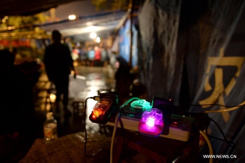 Mobile phone batteries are charged at a temporary settlement for quake-affected people in Lushan County, southwest China's Sichuan Province, April 23, 2013. A rainfall hit Lushan on Tuesday, the fourth day after a 7.0-magnitude jolted the county on April 20. (Xinhua/Li Gang) 