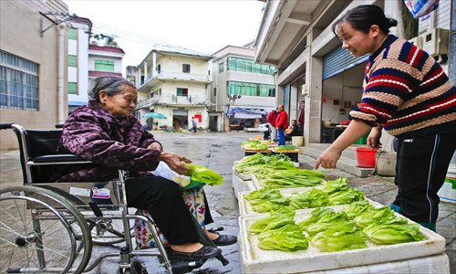 Huang Qihuan, 94, a zishunü in Shunde, buys vegetables.  Her relatives attempted to hire a carer for her, but she refused and insists on living by herself. Photo: CFP