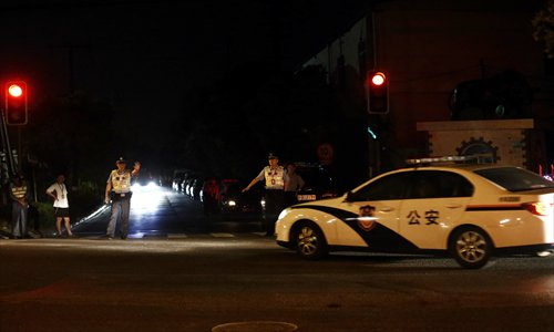 Two policemen stop a police car entering the crime scene after a suspect surnamed Fan killed five people in Baoshan district in Shanghai including a security guard. Photo: Cai Xianmin/GT