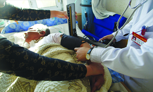 Li Guiying, 63, a patient in a vegetative state, has her blood pressure checked at a dedicated unit in Harbin, Heilongjiang Province. After a month's treatment there, Li's relatives decided to allow her to pass on. Photo: CFP