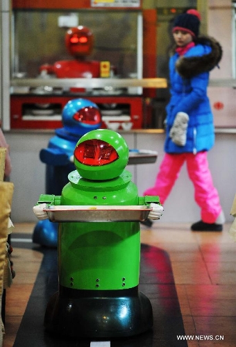 Robots serve dishes in a robot themed restaurant in Harbin, capital of northeast China's Heilongjiang Province, Jan. 18, 2013. Opened in June of 2012, the restaurant has gained fame by using a total of 20 robots to cook meals, deliver dishes and greet customers. (Xinhua/Wang Jianwei) 