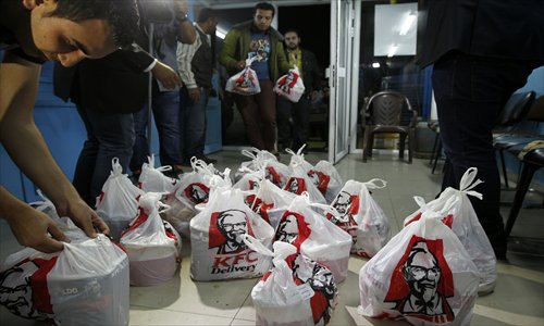 Delivery employees organize bags of food from KFC after it arrived in Gaza City through an underground tunnel linking the Gaza Strip to Egypt on Thursday. Fast food is just the latest trend for smugglers seeking to earn a buck by bringing in hard-to-get products to the Gaza Strip, which has been under an Israeli blockade since 2007. Photo: AFP