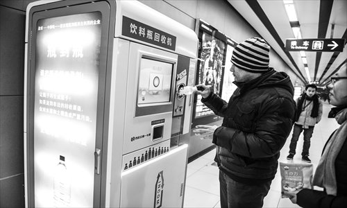 A man puts an empty bottle into a machine which can let subway riders recycle bottles for credit. The machines were put into use in Jinsong and Shaoyaoju stations on Subway Line 10 Thursday. Photo: Li Hao/GT