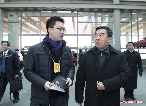Fu Kecheng (R front), a member of the 12th National Committee of the Chinese People's Political Consultative Conference (CPPCC) from east China's Jiangxi Province, receives an interview upon his arrival in Beijing, capital of China, March 1, 2013. The first session of the 12th CPPCC National Committee will open on March 3. (Xinhua/Wang Ye)
