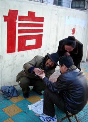 A sidewalk palm reading Photo: CFP