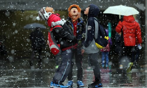 Children in South Korea's northeastern Gangwon province try to taste the snow as it falls on Wednesday, when heavy snow was forecast to hit the region. Photo: CFP