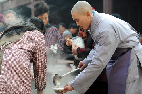  A monk distributes porridge to citizens at the Pilu Temple in Nanjing, capital of east China's Jiangsu Province, Jan. 19, 2013, to celebrate the traditional Laba Festival. Laba literally means the eighth day of the 12th lunar month. The Laba Festival is regarded as a prelude to the Spring Festival, or Chinese Lunar New Year, the most important occasion of family reunion, which falls on Feb. 10 this year. Eating porridge is an old tradition on the Laba Festival in China. Many temples also have the tradition of offering porridge to the public to commemorate Buddha and deliver his blessings to both believers and non-believers. (Xinhua/Han Yuqing) 