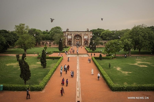 Tourists visit the gardens at Humayun's Tomb in New Delhi, capital of India, May 12, 2013. Humayun's Tomb, located in east New Delhi, was built in 1569 to 1570 by Humayun's widow. As a precursor to the Taj Mahal, it stands on a platform of 12,000 square meters and reaches a height of 47 meters. The earliest example of the Persian influence in Indian architecture, the tomb itself is in the center of a large garden, surrounded by 12 hectares of gardens with pools joined by channels. The tomb brought Persian style to Delhi, but the two-tone combination of red sandstone and white marble is local, which shows the merging of different cultures. Humayun's Tomb was inscribed on the World Heritage List by the United Nations Educational, Scientific and Cultural Organization in 1993. (Xinhua/Zheng Huansong) 