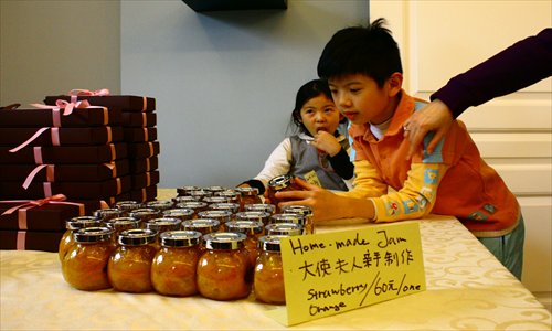 A boy checks out the homemade jam at the charity sale Sunday. Photo: CFP