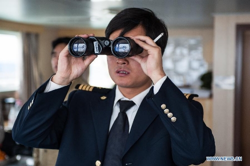 Zhu Hui checks sailing conditions using telescope aboard the Maple Star on the Yangtze River in east China's Jiangsu Province, April 24, 2013. (Xinhua/Li Mangmang) 