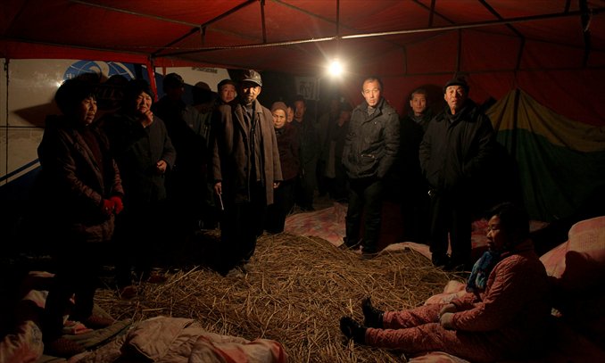 Villagers stand in a tent on December 6 in Yingshang, Anhui Province. They stayed there for days guarding a bus they seized from local authorities who allegedly beat 14 villagers in the vehicle which was used to take kidnapped petitioners from Beijing home. Photo: CFP