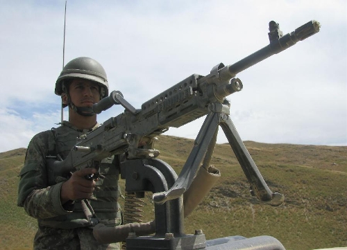 An Afghan policeman keeps watch on a military vehicle with a machine gun on the border between Afghanistan and Pakistan in Goshta district of nangarhar province in eastern of Afghanistan on May 7, 2013. Afghanistan summoned on Monday the Pakistani Charge d'Affaires and lodged protest over 