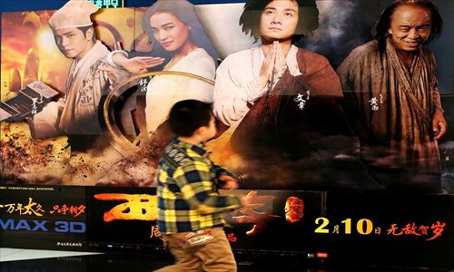 A boy passes a poster for the film Journey to the West: Conquering the Demons at a cinema in Shanghai Monday. Photo: Yang Hui/GT