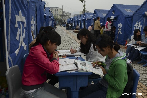 High school students study to prepare the college entrance exam this summer outside tents at a temporary settlement at the Tianquan Middle School in quake-hit Tianquan County, Ya'an City, southwest China's Sichuan Province, April 22, 2013. A 7.0-magnitude earthquake jolted Lushan County of Ya'an City in the morning on April 20. (Xinhua/Wang Jianhua)