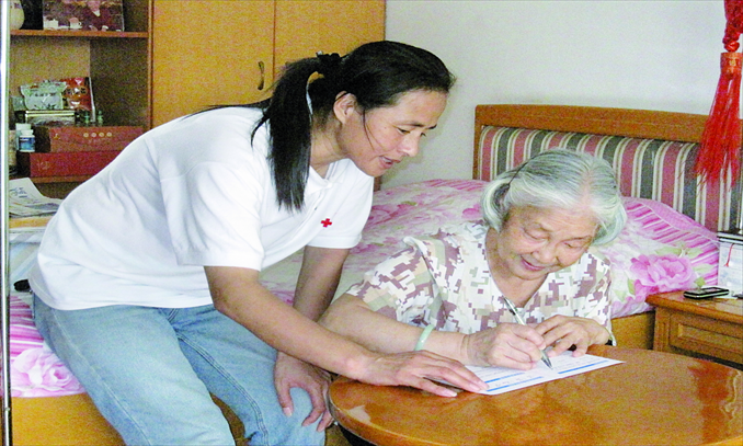 With the help of Gao Min (left), a professional organ donation coordinator, Liu Youxue fills out a form to donate her husband's corneas and body in Shenzhen on August 25, 2010. Liu's husband died a year later at the age of 92. Photo: Courtesy of Gao Min