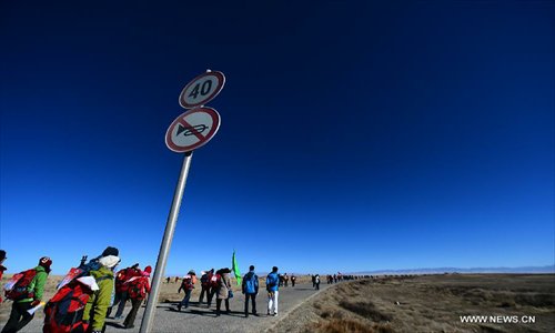 Hikers walk along Qinghai Lake, northwest China's Qinghai Province, January 1, 2013. 