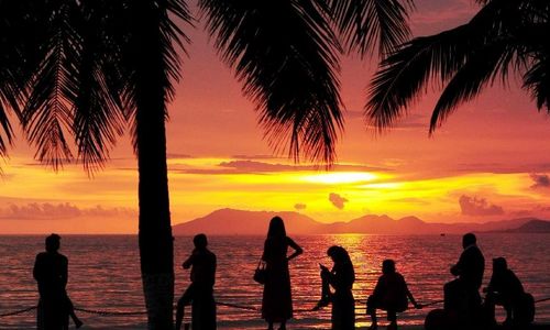 People enjoy themselves by the sea in the afterglow at Sanya Bay in Sanya, South China's Hainan Province, August 20, 2012. Photo: Xinhua