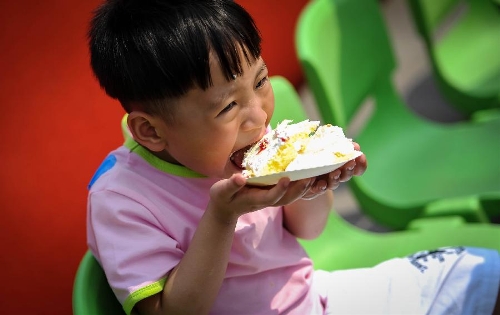 A young boy eats cake at the Luohan Temple in Shifang City, southwest China's Sichuan Province, May 12, 2013. The boy was born at the Luohan Temple five years ago after the devastating earthquake jolted Wenchuan County of Sichuan on May 12, 2008. The temple then was used as a temporary obstetrics hospital from May 13 to Aug. 7 in 2008 to deliver newborn babies. A total of 108 babies were born at the temple until the local maternal and child health care hospital reopened. (Xinhua/Jiang Hongjing) 