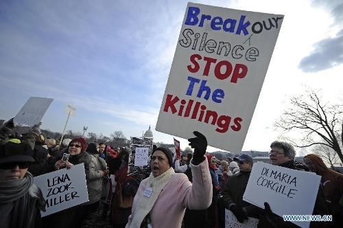 People hold signs against gun violence in front of the Capitol Hill during a march in Washington D.C., capital of the United States, Jan. 26, 2013. Thousands of people, including family members of victims and survivors of shootings at Virginia Tech University, Sandy Hook elementary school and others, took part in a march for stricter gun control laws here on Saturday. (Xinhua/Zhang Jun) 