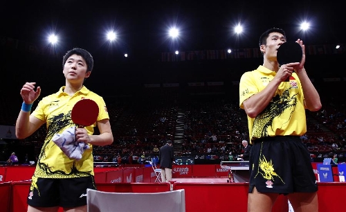 Wang Liqin (R) and Rao Jingwen of China react after the first round of mixed doubles against Thavisack Phathaphone and Thiphakone Southammavong of Laos at Palais omnisport de Paris Bercy in Paris, France, on May 14, 2013. Wang and Rao won 4-0. (Xinhua/Wang Lili) 