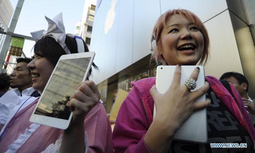 A girl shows her newly-bought Apple iPad mini in front of the Apple Store Ginza in Tokyo, capital of Japan, on November 2, 2012. Sales of the new iPad mini tablet computer started in Japan on Friday. Photo: Xinhua