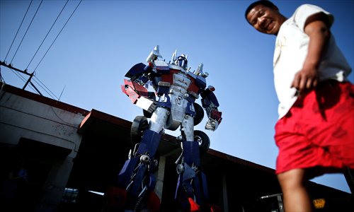 A man walks past a handmade Gundam model at a factory in Baoshan district Tuesday. The four-meter tall model was created by the neighboring factory to promote its manufacturing capability. Photo: Yang Hui/GT