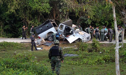 Thai bomb squad members inspect the site of a roadside bomb attack by suspected separatist militants on a pick-up car carrying soldiers in Thailand's restive southern province of Narathiwat on Wednesday.  One soldier was killed and two injured in the attack. Photo: AFP