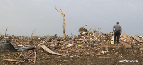 A police officer surveys damage after a tornado in Moore, Oklahoma, the United States, on May 20, 2013. Twenty-four people were killed and 237 others injured when a massive tornado blasted the southern suburbs of Oklahoma City, the capital of the U.S. state of Oklahoma, on Monday, state officials said Tuesday. (Xinhua/Marcus DiPaola)