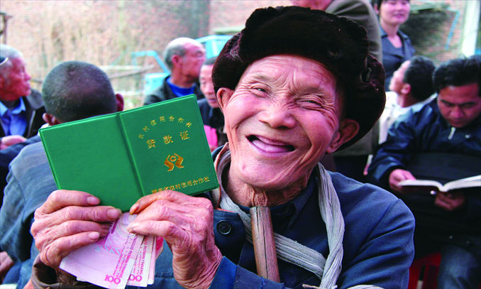 Zhao Chengrong, an elderly farmer from Wufeng township, Hunan Province, is happy to get a preferential loan of 500 yuan to prepare for the coming spring ploughing on March 2, 2011. Photo: IC
