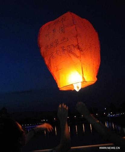 Students fly a Kongming lantern, a small hot-air paper balloon, to pray for Wang Jialin and Ye Mengyuan, two young girls killed in a crash landing of an Asiana Airlines Boeing 777 at San Francisco airport, in Jiangshan City, east China's Zhejiang Province, July 8, 2013. Local residents gathered at Xujiang Park in Jiangshan to show their grief to the 17-year-old Wang and 16-year-old Ye, who were students from Jiangshan High School. (Xinhua/Huang Shuifu)