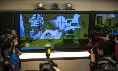 Reporters take photos at the television screen at Beijing Ditan Hospital stating the condition of the capital's first H7N9 patient, a 7-year-old girl, who was placed under observation at an intensive care unit on Saturday. Photo: Li Hao/GT