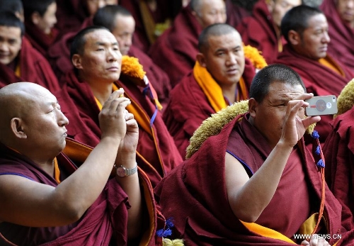 &nbsp; Monks take photos at the ceremony of defending dissertations for Gexe Lharampa, the highest academic degree in Tibetan Buddhism studies, at the Jokhang Temple in Lhasa, capital of southwest China's Tibet Autonomous Region, April 5, 2013. Eight laureates of Gexe Lharampa were awarded here on Friday after they passed tests and defended their dissertations. Gexe means knowledgeable and Lharampa is the highest among the four ranks in the Gexe system. (Xinhua/Chogo)&nbsp; 
