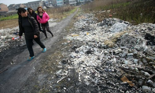 People pass a battery factory in Luqiao district, Taizhou, Zhejiang Province, on March 24, 2011. The factory discharged pollutants into the soil, which led to serious contamination of the surrounding water and resulted in hundreds of people having elevated levels of lead in their blood. Photo: IC