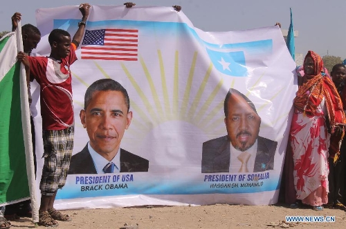 Somalians hold a poster depicting U.S. President Obama and Somalian President Hassan Sheikh Mohamud during a rally in Mogadishu, Somalia, on Jan. 21, 2013. Hundreds have rallied on Monday to mark the United State administration's recognition of the Somali government following a state visit by Somalia's leader to the U. S. last week.(Xinhua/Faisal Isse) 