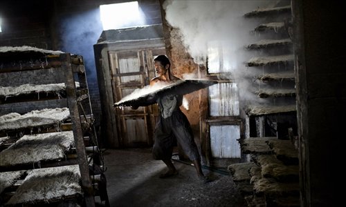 A worker carries noodles or mie lethek after the steaming process at a mie lethek factory in Srandakan village, Bantul in Indonesia on Wednesday. Yasir Feri Ismatrada took on the family business of mie lethek production founded by his grandfather. Yasir puts great importance on the fair treatment of his 40 staff, with management profits capped at 10 percent, prioritizing staff interests. Mie lethek are sold for 80 cents per kilogram. Photo: CFP