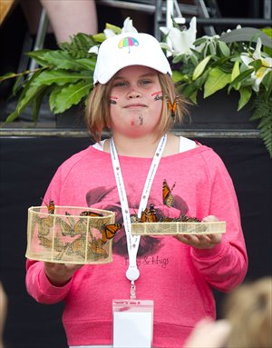 A Christchurch youth releases some of the 185 Monarch butterflies symbolizing the 185 people who lost their lives in last year's earthquake during a remembrance service in Hagley Park in Christchurch yesterday, one year after a 6.3-magnitude quake hit New Zealand's second largest city.  Photo: AFP