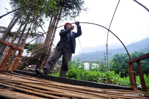 Villager Gao Kaimin, 50, makes use of a bed to build a tent in quake-hit Yuxi Village of Lushan County, southwest China's Sichuan Province, April 23, 2013. A 7.0-magnitude jolted Lushan County on April 20. (Xinhua/Xiao Yijiu) 