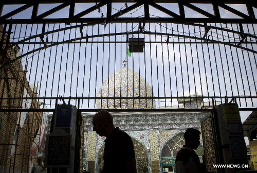 Iranians walk past a mosque at Tehran's old main bazaar in downtown Tehran, Iran, on May 20, 2013. Economic condition of Iranian families is the core issue of the hopeful candidates for Iran's 11th presidential election, as the inflation rate of the Islamic republic, according to the Iranian Statistics Center, reached 29.8 percent in the first month of the current Iranian calendar year (March 21-April 20). (Xinhua/Ahmad Halabisaz) 