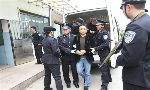 Zhang Fulin and his wife Ye Tingying are escorted by police after arriving at the Wenzhou Yongqiang Airport on Sunday. The couple were arrested in Vietnam on Wednesday. Photo: CFP