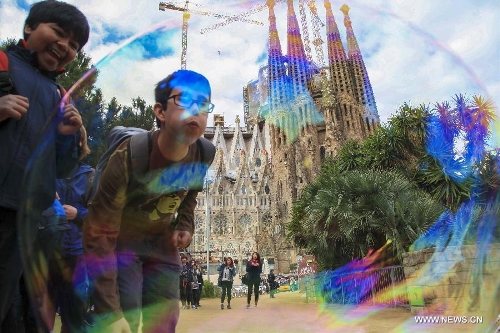 A busker makes soap bubbles in front of the Basilica and Expiatory Church of the Holy Family in Barcelona, Spain, on April 10, 2013. The Roman Catholic church, commonly known as the Sagrada Familia, was designed by Antoni Gaudi (1852-1926) and its construction had commenced in 1882. Although being incomplete after over 130 years, the church is a UNESCO World Heritage Site. (Xinhua/Sun Wen) 