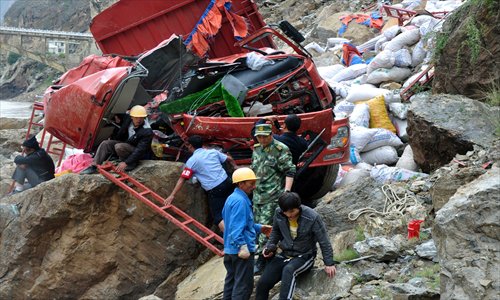 Armed police officers in Shangri-La county, Yunnan Province, on Saturday try to rescue the driver trapped in a truck near a scenic spot following a 5.9-magnitude earthquake at the border area of Yunnan and Sichuan Province. Photo:IC