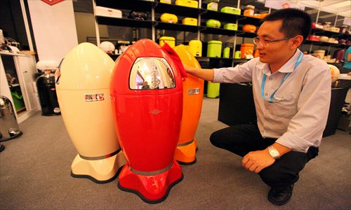 An exhibitor shows garbage receptacles shaped like artillery shells Tuesday at the Interior Lifestyle China 2012 exhibition, which opens at Shanghai Exhibition Center Wednesday. Photo: Cai Xianmin/GT