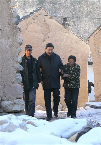 Xi Jinping (C), general secretary of the Communist Party of China (CPC) Central Committee and chairman of the CPC Central Military Commission, visits the family of Tang Zongxiu (R), an impoverished villager in the Luotuowan Village of Longquanguan Township, Fuping County, north China's Hebei Province, Dec. 30, 2012. Xi made a tour to impoverished villages in Fuping County from Dec. 29 to 30, 2012.   Photo: Xinhua