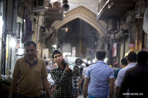 A man carries fabric at Tehran's old main bazaar in downtown Tehran, Iran, on May 20, 2013. Economic condition of Iranian families is the core issue of the hopeful candidates for Iran's 11th presidential election, as the inflation rate of the Islamic republic, according to the Iranian Statistics Center, reached 29.8 percent in the first month of the current Iranian calendar year (March 21-April 20). (Xinhua/Ahmad Halabisaz) 