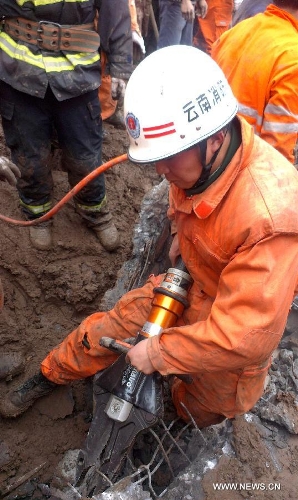 Rescuers work at the landslide site at Gaopo Village of Zhenxiong County, southwest China's Yunnan Province, Jan. 11, 2013. More than 10 residential houses with over 40 people were buried after a landslide happened at the village early Friday morning, according to local officials. Eight people have been confirmed dead by now. (Xinhua)&nbsp; 
